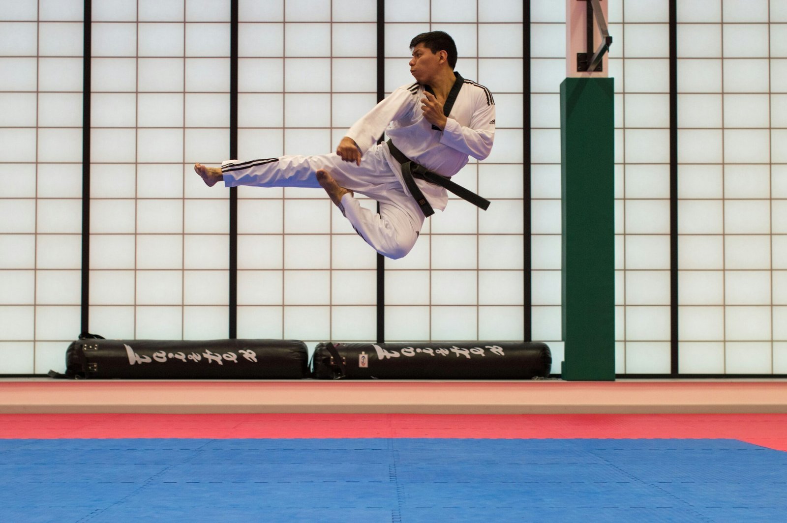 man-doing-karate-stunts-on-gym-scaled-1 فن الدفاع عن النفس: كيف تختار الفن المناسب لك؟